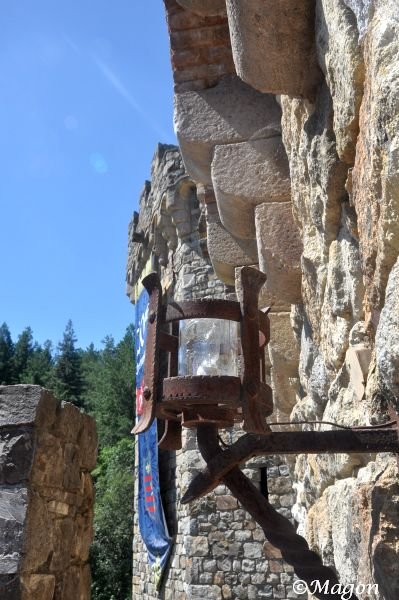 Castello Di Amorosa: ржавый фонарь на каменной стене